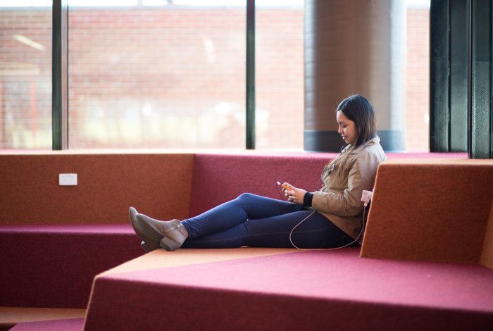 Image: a person reading an eBook on a device in the library