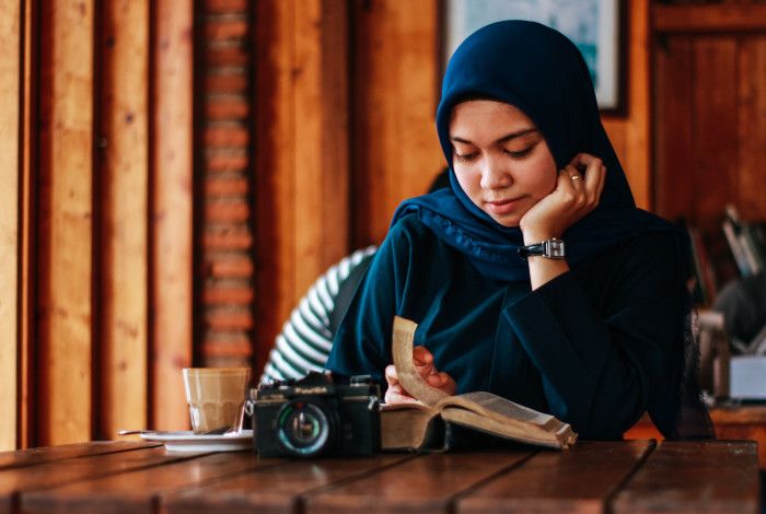 Image: A woman reading at a table