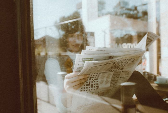 A person reading The Age newspaper