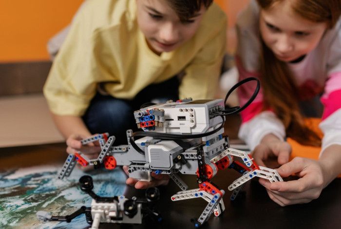Image of a boy and a girl playing with a Lego robotay
