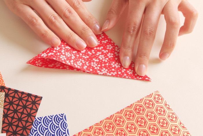 Hands folding decorative paper