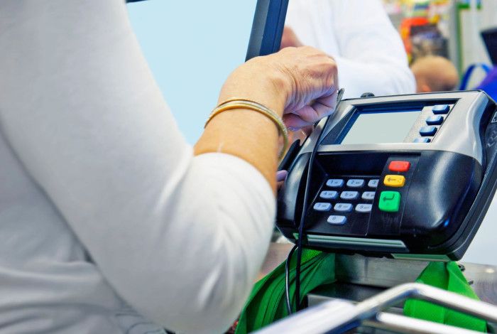 A person using a machine to charge an expense to a card