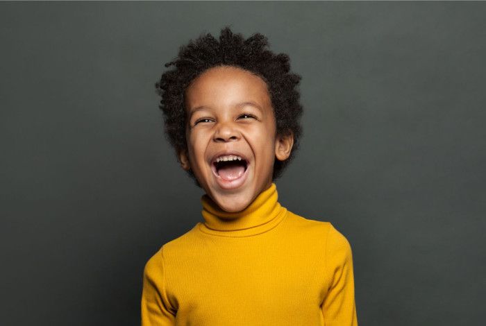 Boy laughing on blank background