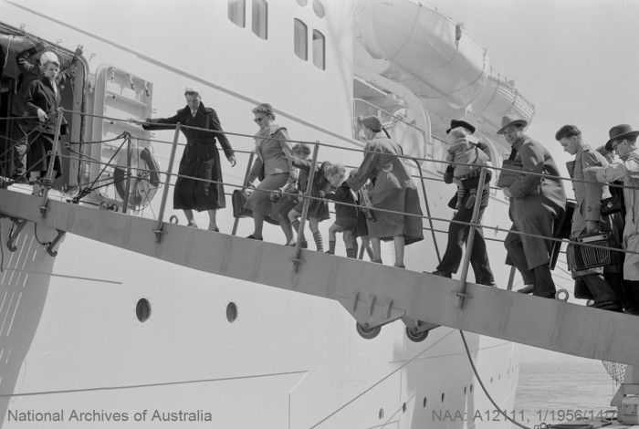 black and white historical photo of people boarding a ship.