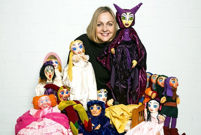 Various puppets on display with presenter.