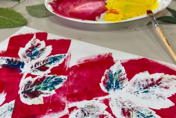 Painting colourful leaves on a white sheet. of paper