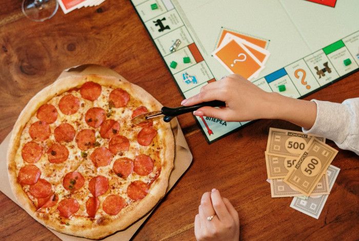 board game and pizza being cut.