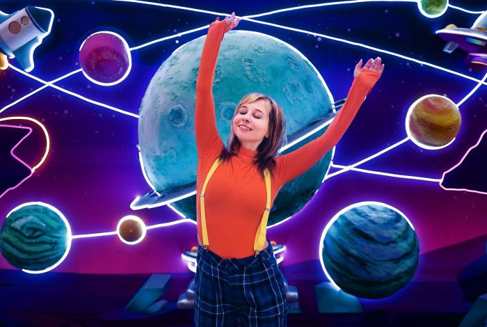 Young woman with raised arms immersed in digital universe.