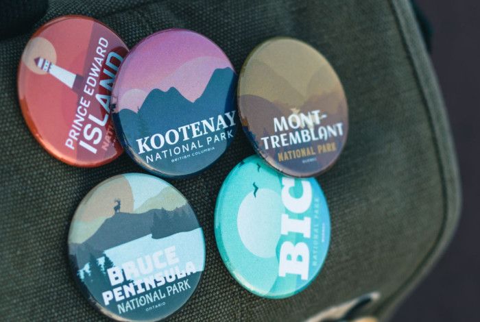 Five badges pinned to a jacket.