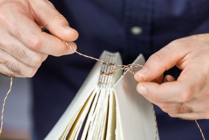 Person sewing a book block.