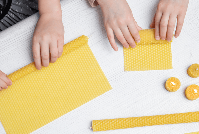 Children using wax sheets to produce candles.