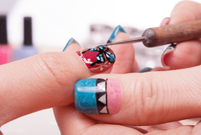 A person decorating nails using nail art techniques.