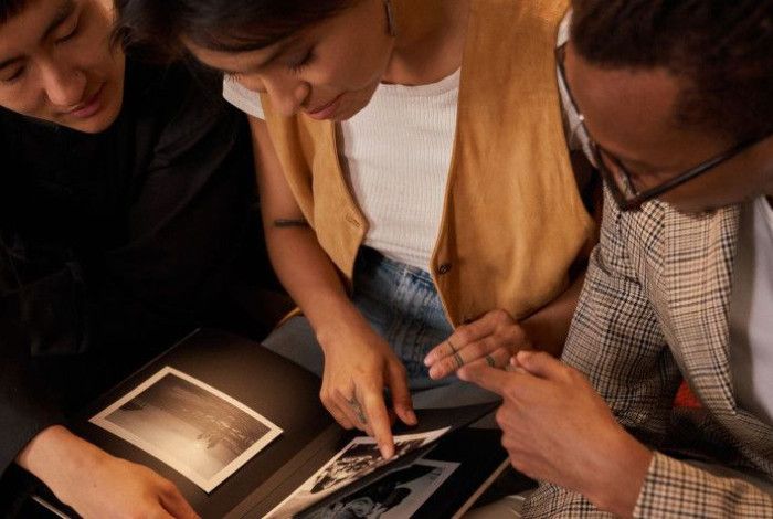 Group of people leafing through a photo album.