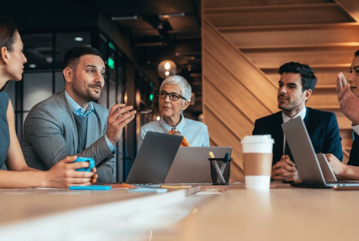 A group of professional people sitting at a table during a business meeting.