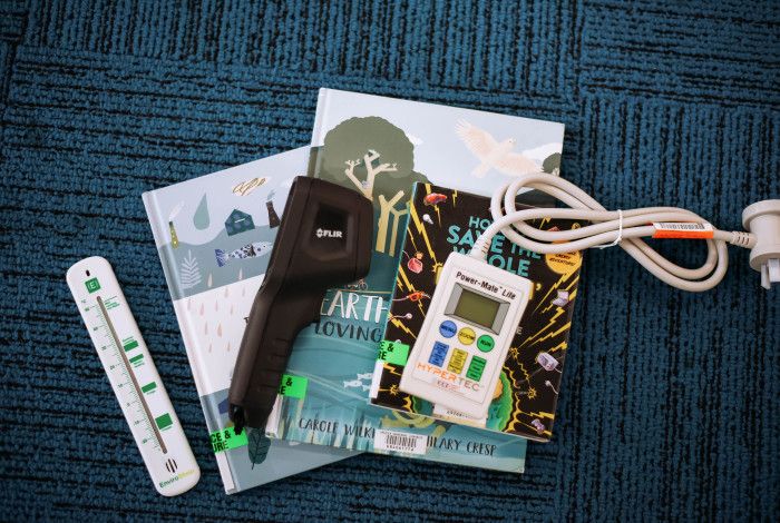 Thermometer, thermal imaging camera and Power Mate Lite devices arranged on library books.
