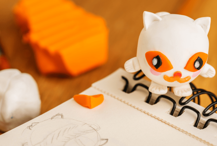 Clay sculpted objects on a table with notebook.