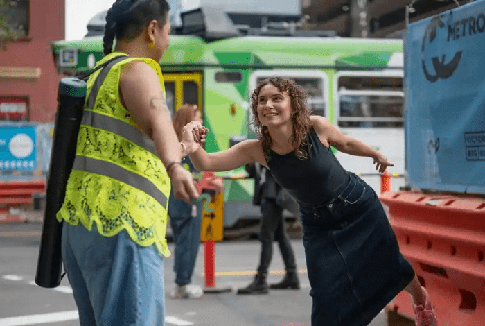 Two people locking hands in an urban environment.
