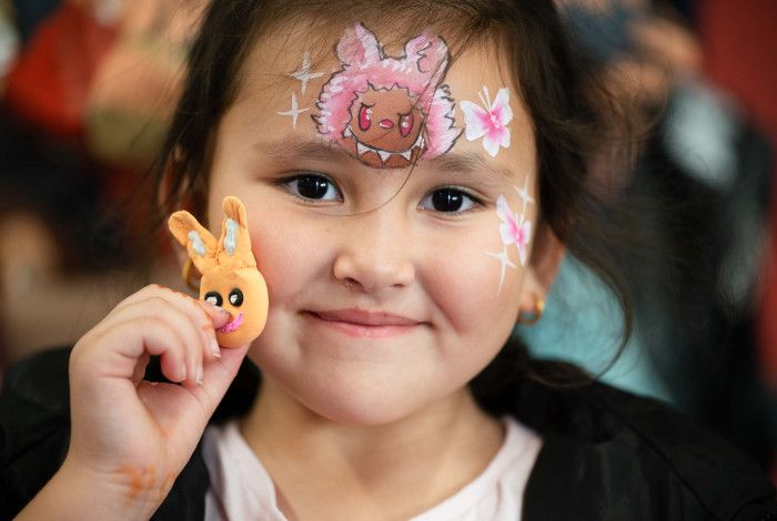 Child  with facepaint at a comic themed event.