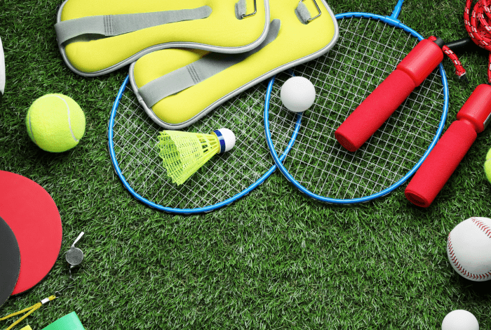 Soccer ball and other sporting equipment on grass,