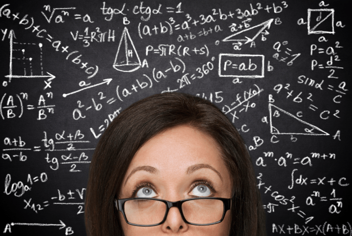  A woman's face  with puzzled expression placed in front of a blackboard covered with mathematical equations.