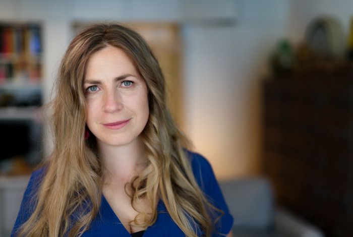 Author Kate Solly in front of a bookshelf. 