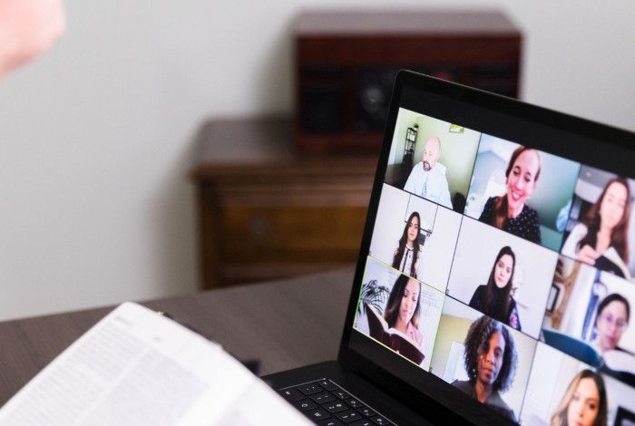 Person using laptop for online meeting.