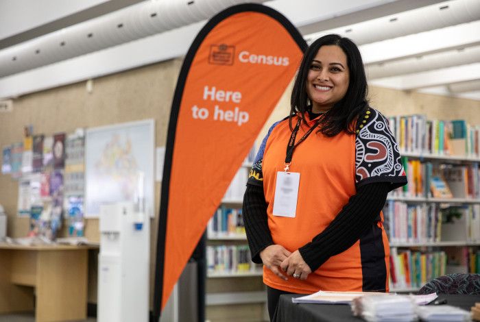 Official standing next to a census help sign.