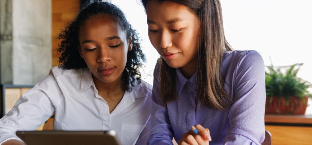 Image: two young girls looking at a tablet device
