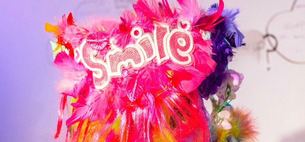 Brightly coloured feathers and the word 'smile' appears.