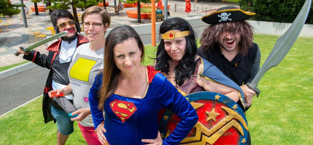 A small group of people dressed in costumes, for example, a superhero and a pirate.