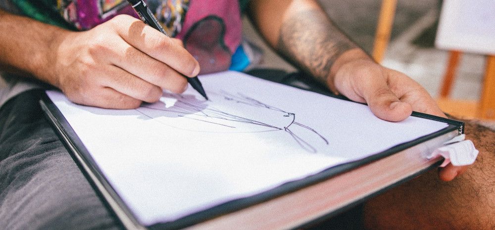 A person drawing on a page. 