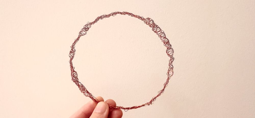A bracelet made of red wire. 