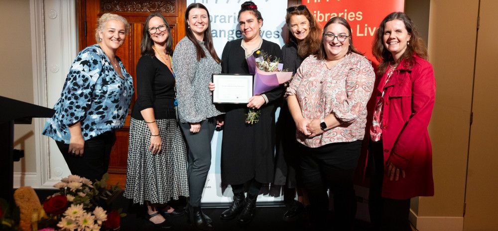 A number of people gathered on a stage receiving an award.