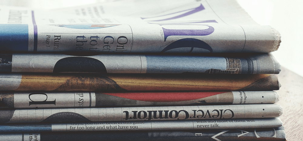 Newspapers folded and stacked on top of each other.