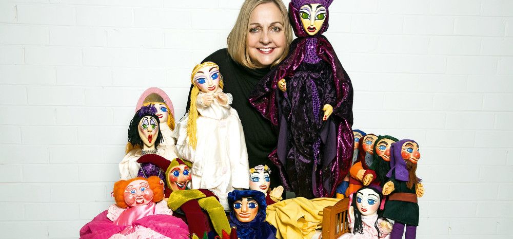 Various puppets on display with presenter.