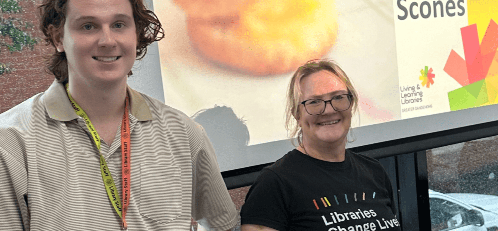 Staff members at Greater Dandenong Libraries standing in front of a screen.