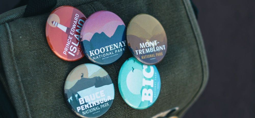 Five badges pinned to a jacket.
