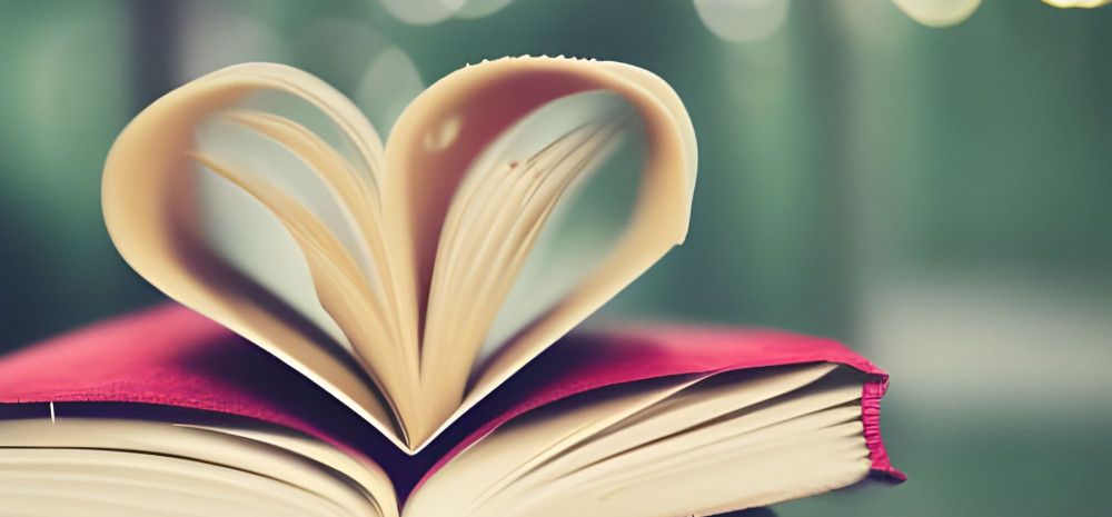 Open book with pages folded in the shape of a love heart.