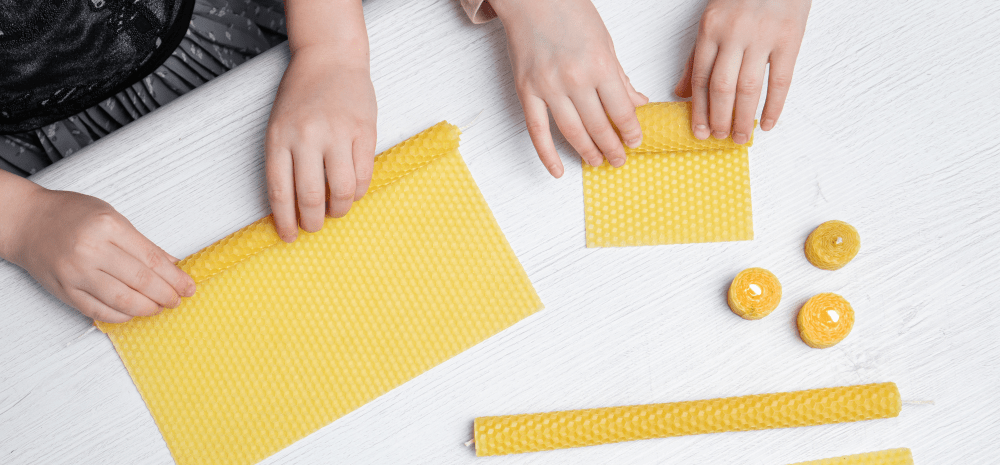 Children using wax sheets to produce candles.