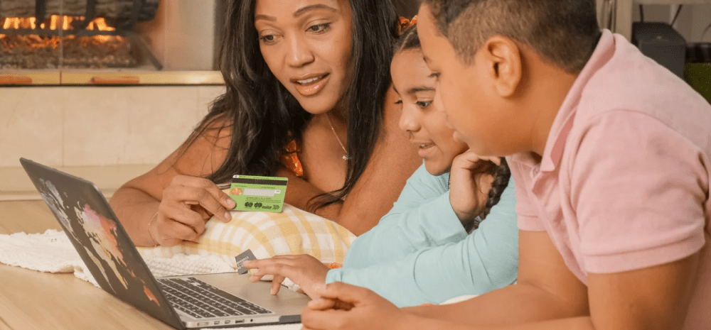 Mother and two children using laptop for online purchase.