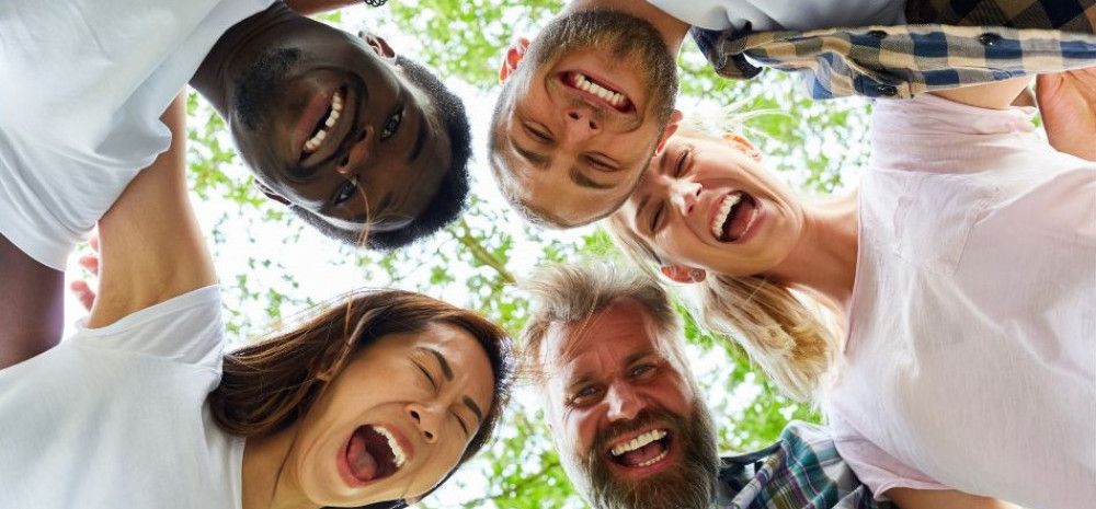 Group of five people laughing in a circle