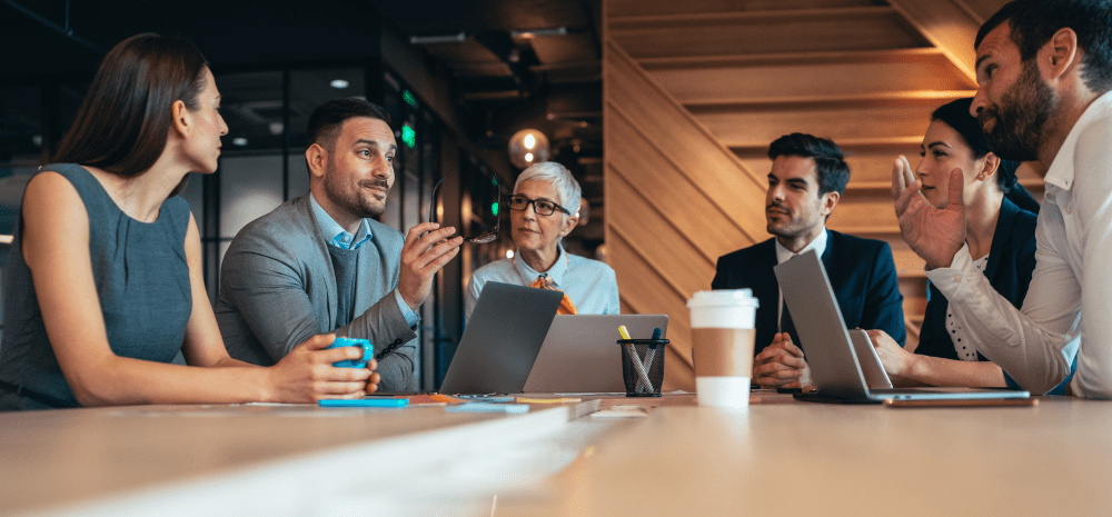 A group of professional people sitting at a table during a business meeting.