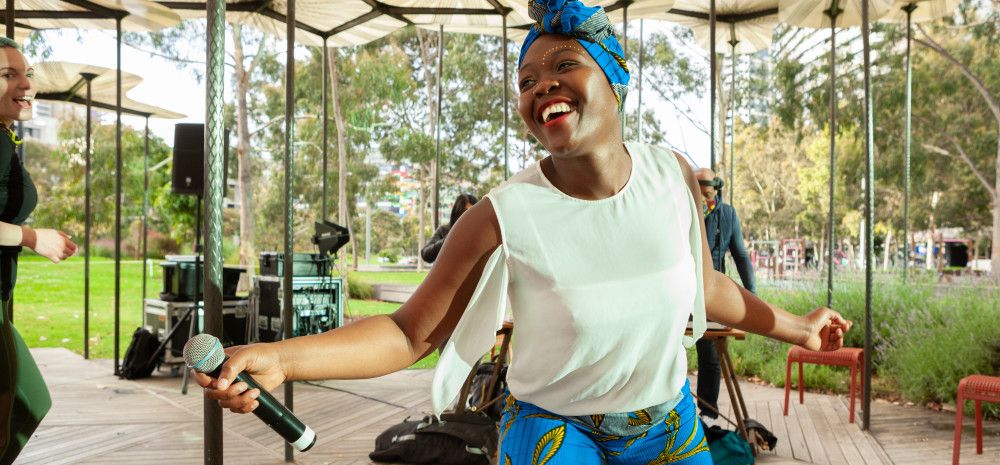 Kwabo dancer on stage with microphone. 
