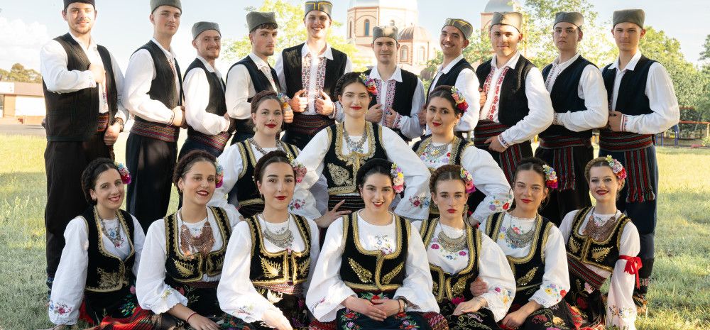 A group photo of Serbian folk dance group Šumadija wearing traditional costumes.