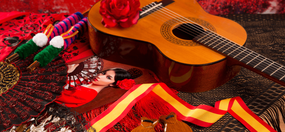A photo of a young Spanish girl in traditional costume displayed together with a guitar and some other symbols of Spanish culture.
