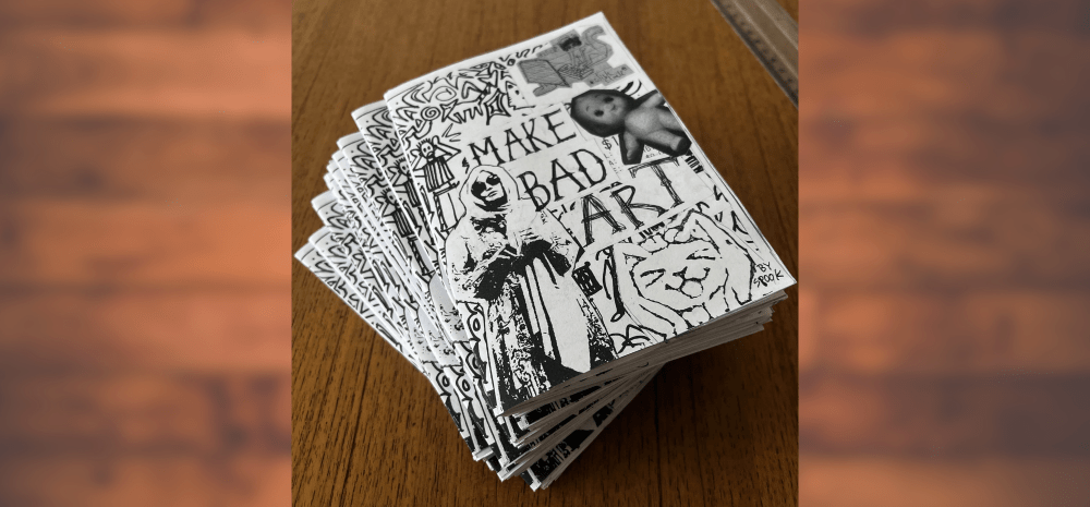 A wooden table with a stack of Zines on it. 