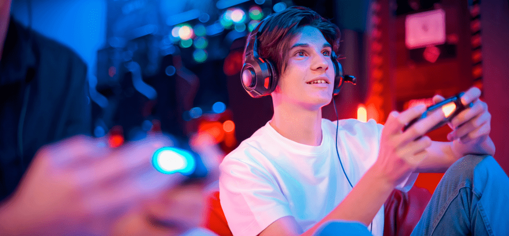 A boy with a gaming headset playing the PlayStation.