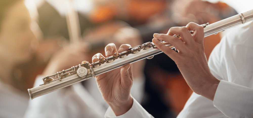 Closeup of person's hands playing a concert flute.