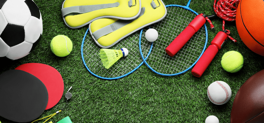 Soccer ball and other sporting equipment on grass,