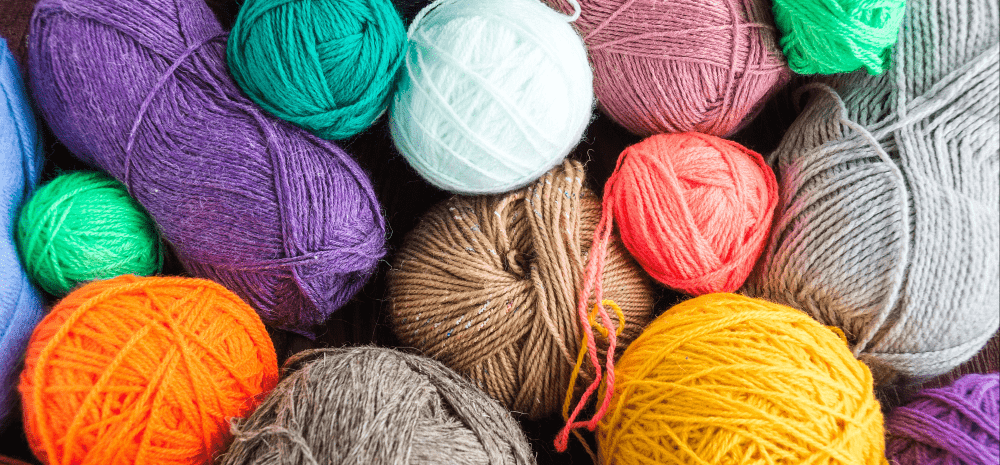 A pile of knitting yarn balls in bright colours.